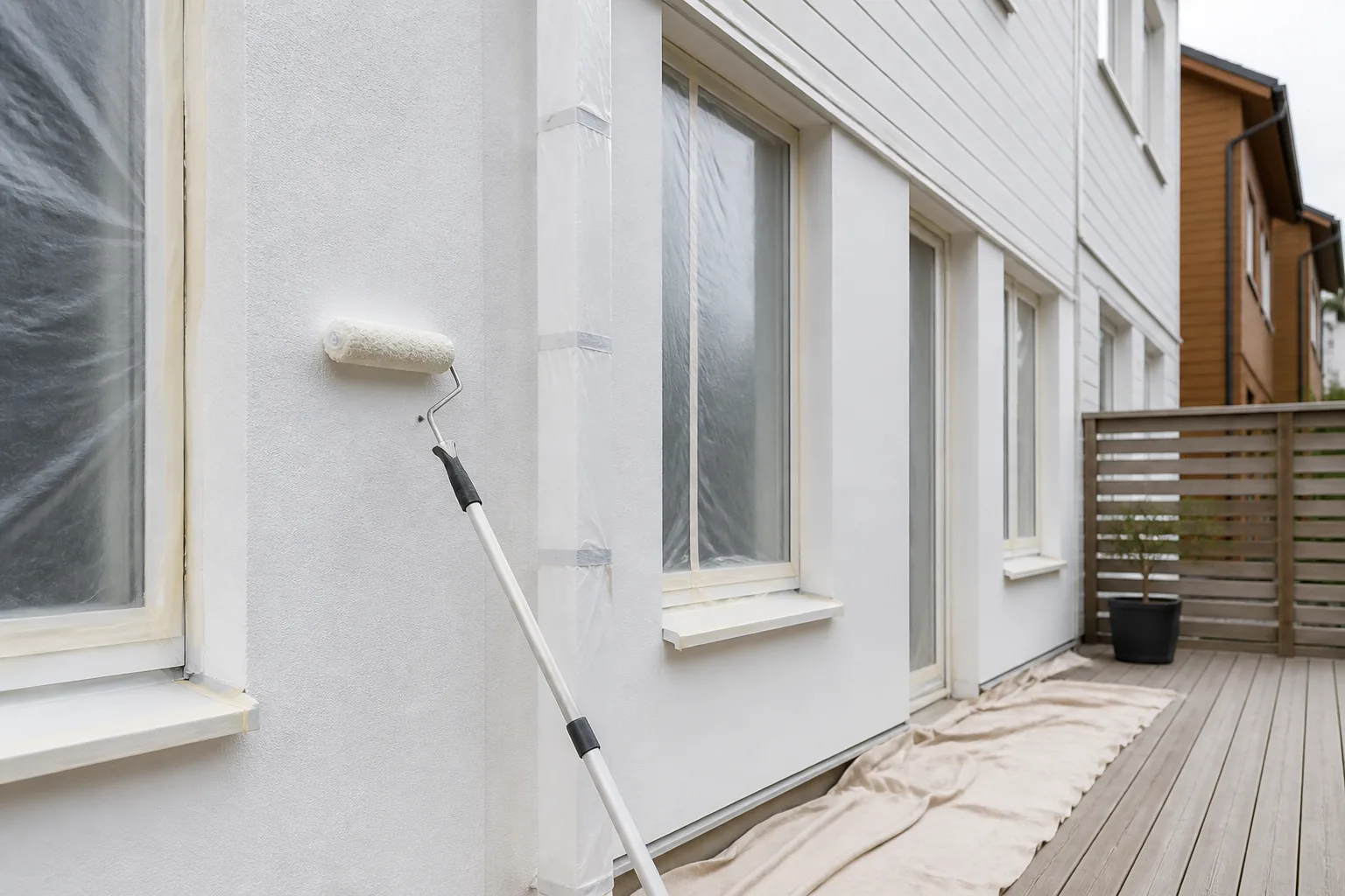 Utvändig fasad som målas med roller och maskerade fönster